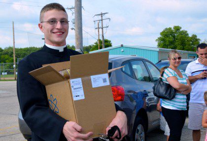 Justin carries in the orders of worship for the ceremony