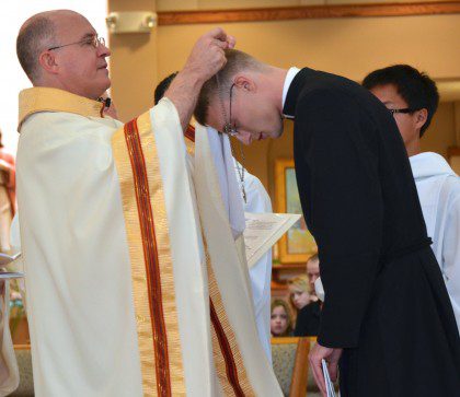 Justin receives his profession cross from Fr. Steve.
