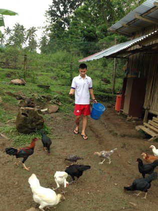 A student feeds the chickens at the formation house