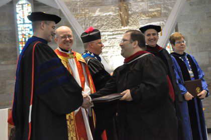 Fr. Steve looks on as an SHSST seminarian receives his diploma. Graduation was on May 1.