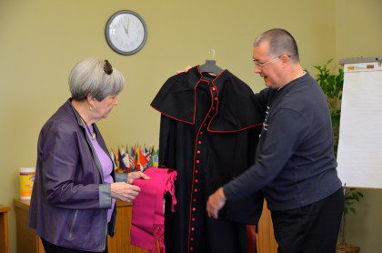 Fr. Wayne shows Patricia one of Bishop DePalma's vestments. 